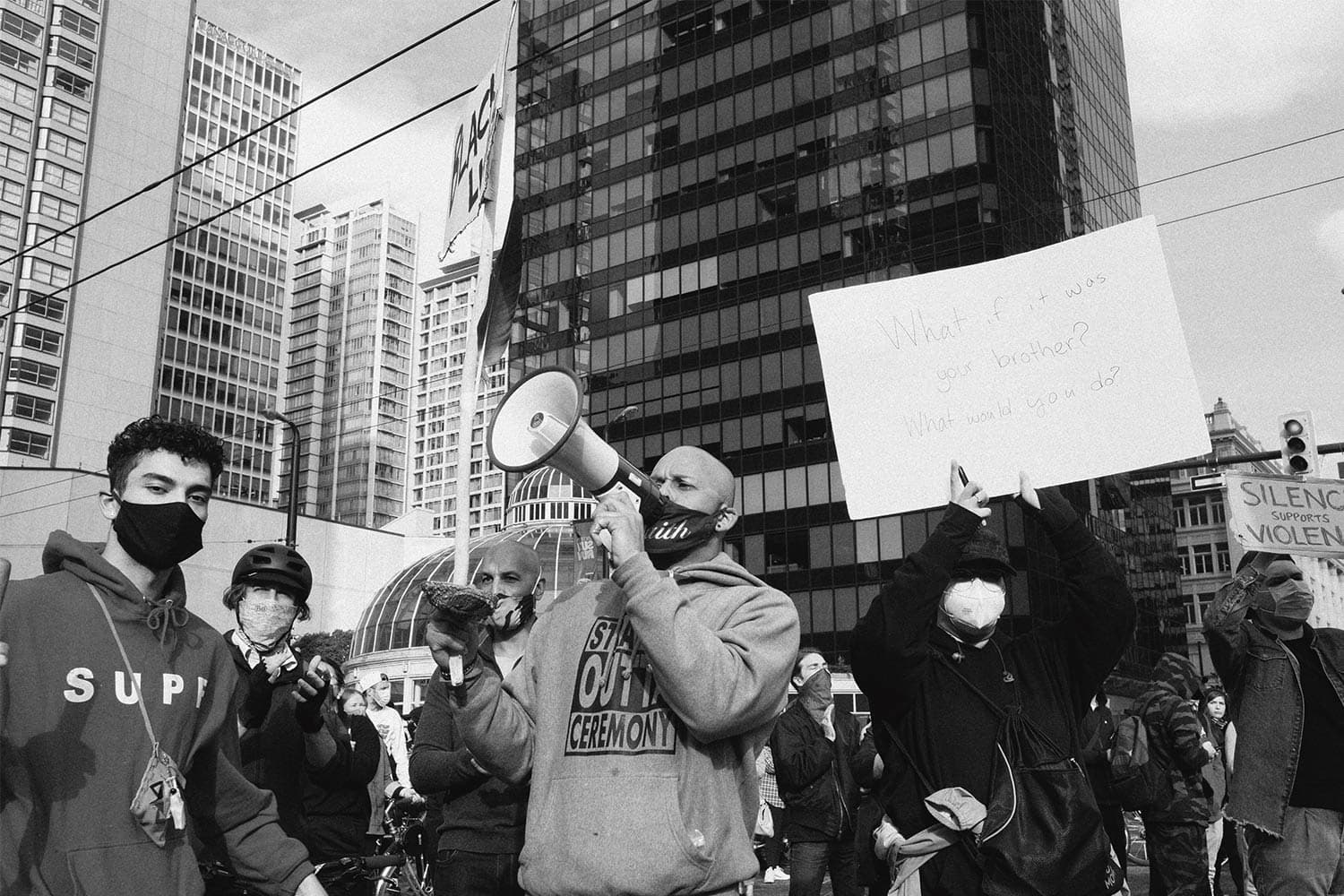Protesters wearing face masks gather in downtown Vancouver holding signs in support of the Black Lives Matter movement.