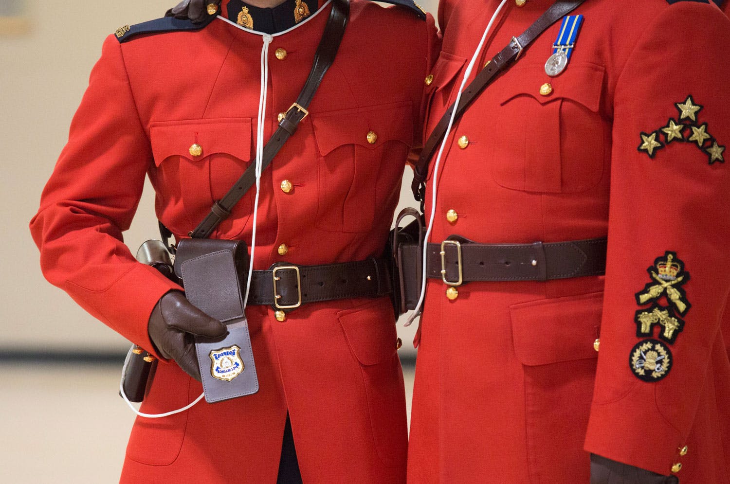 Upper body view of two men wearing red serge RCMP uniform.
